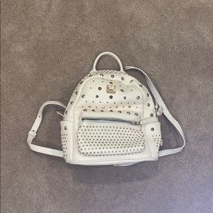 white leather backpack with shiny golden spikes